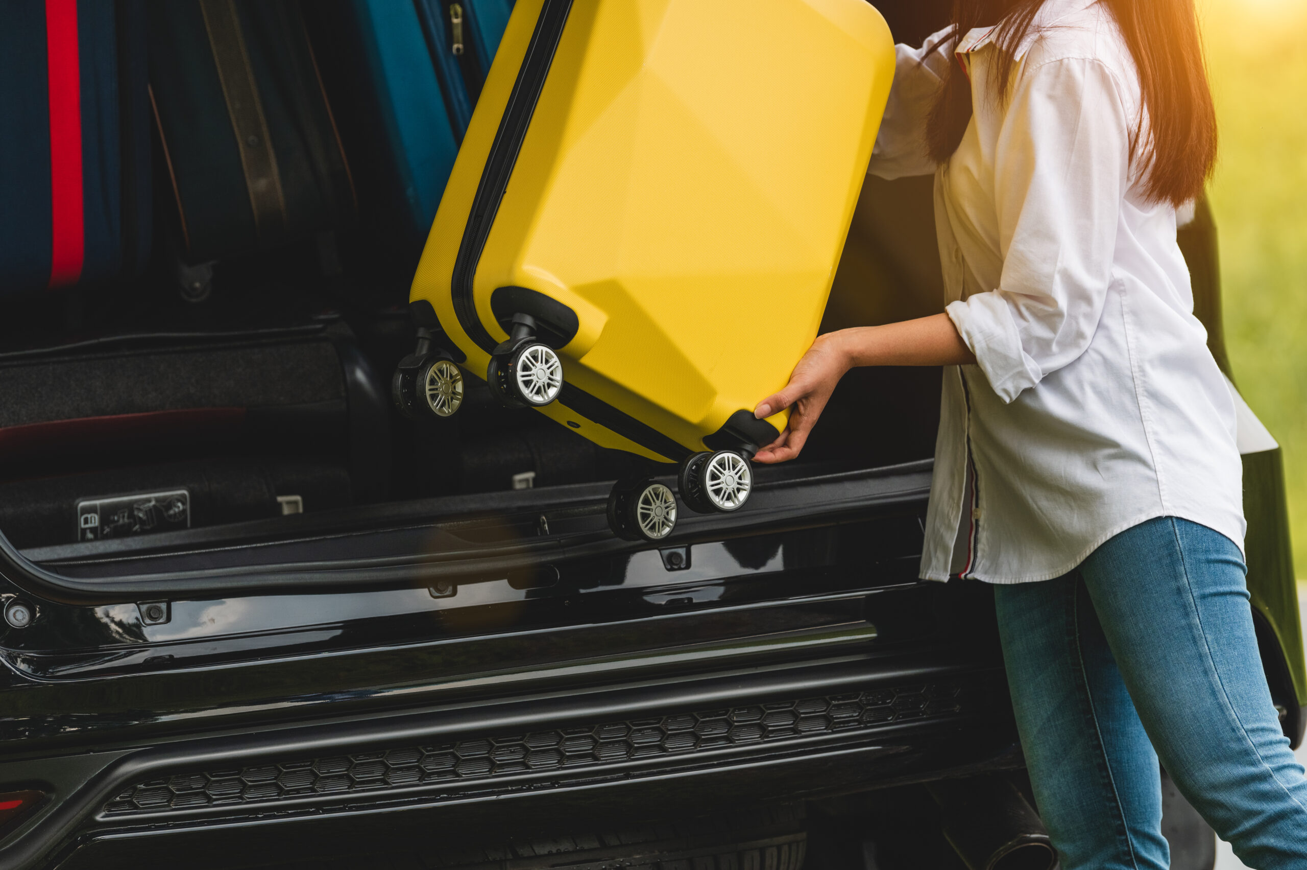 Asiain,Woman,Lifting,Yellow,Suitcase,Into,Suv,Car,During,Travel